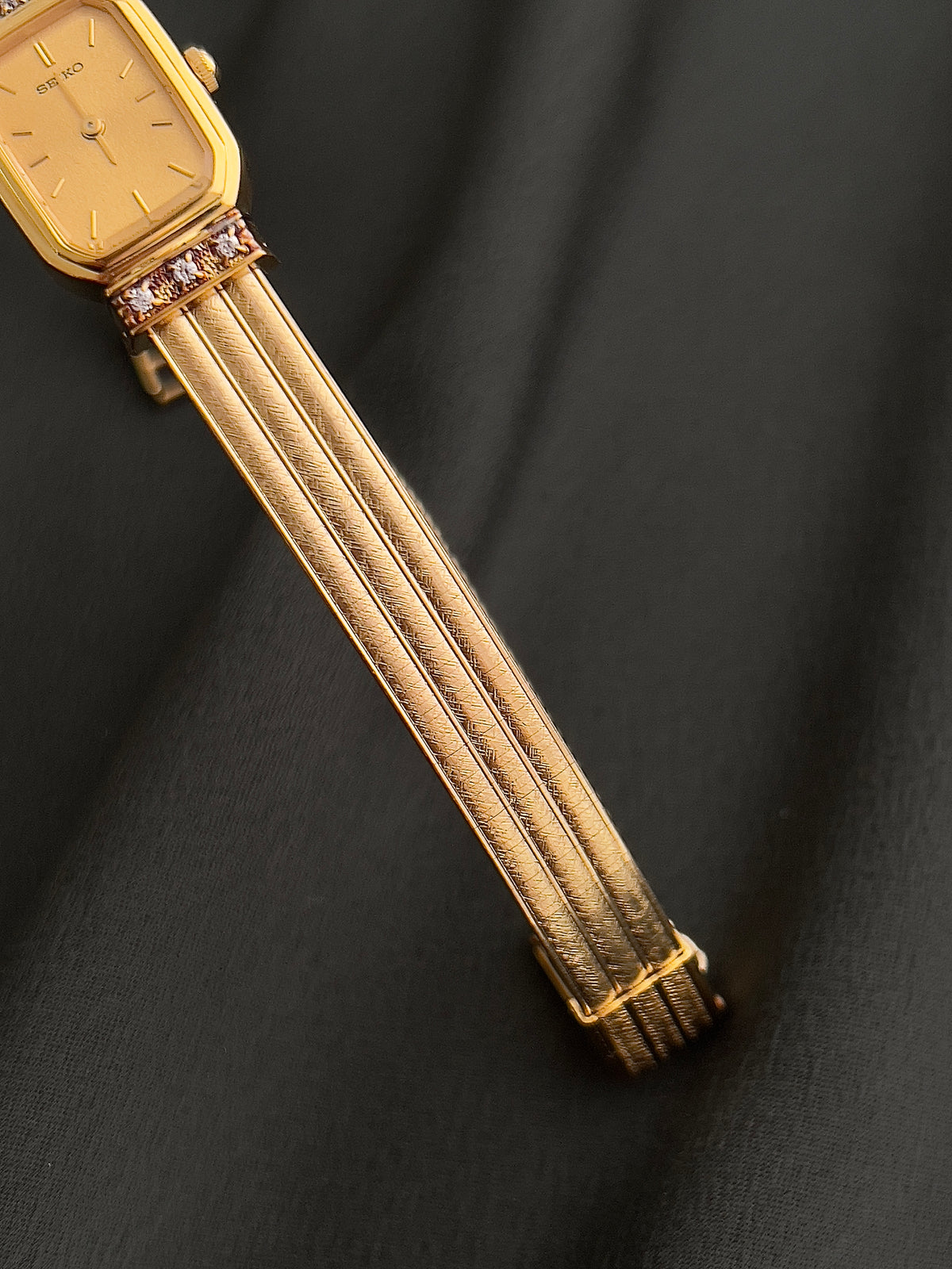 Seiko gold-tone watch displayed with its included box.