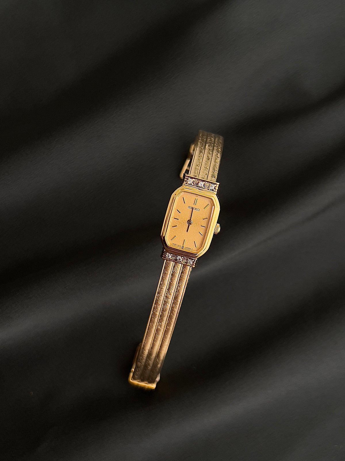 Front view of the Seiko champagne dial and crystal-accented gold case.