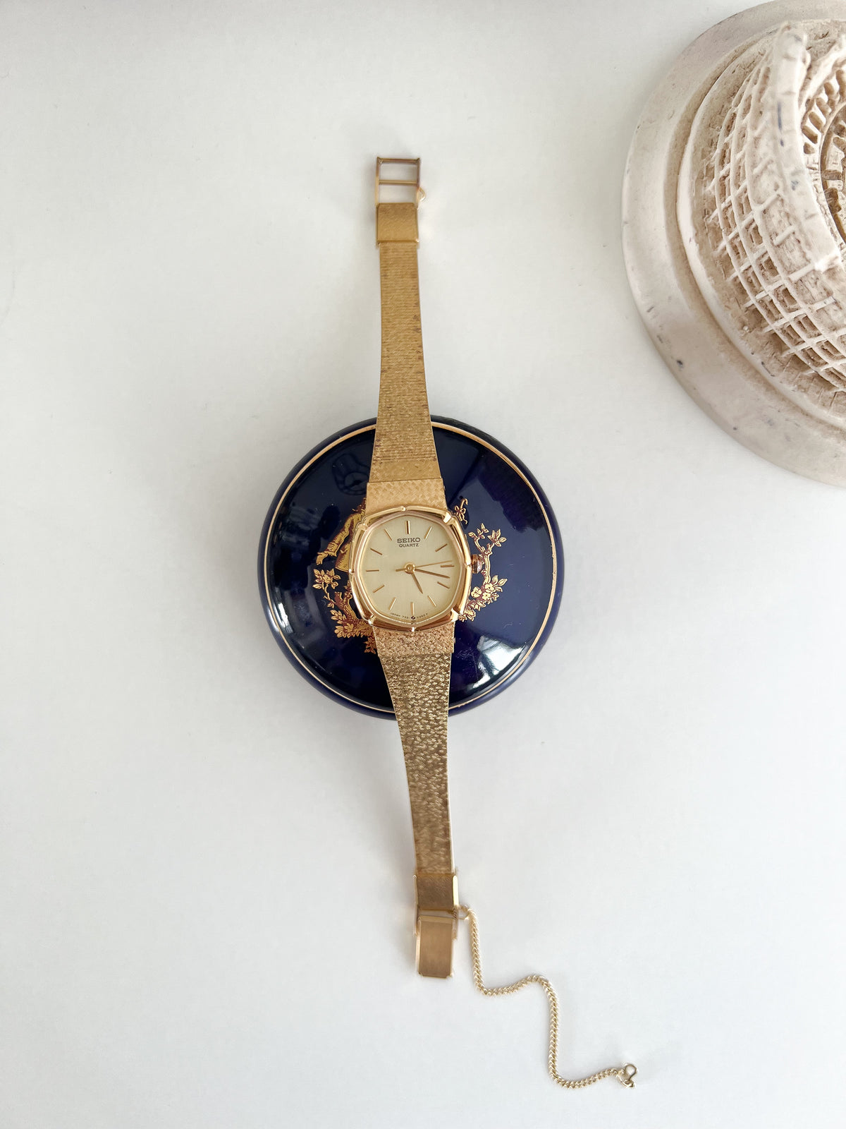 Seiko Gold Cushion Tatami Bracelet Women’s Watch — Full watch displayed vertically over a blue dish