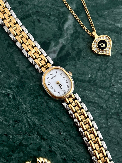 Angled view of the Seiko petite oval gold-tone case and two-tone bracelet.
