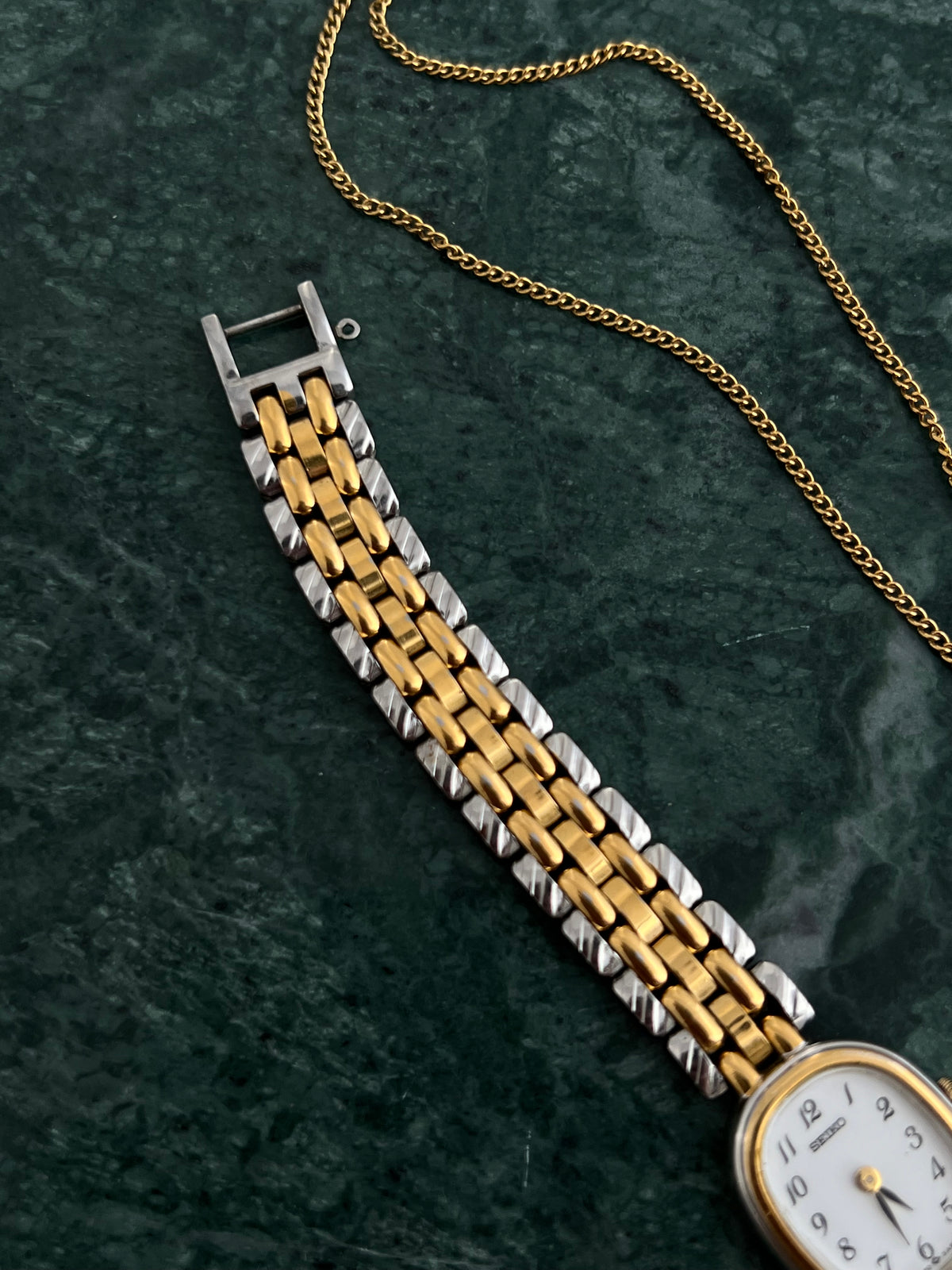 Side profile of the Seiko gold-tone oval case and glass.