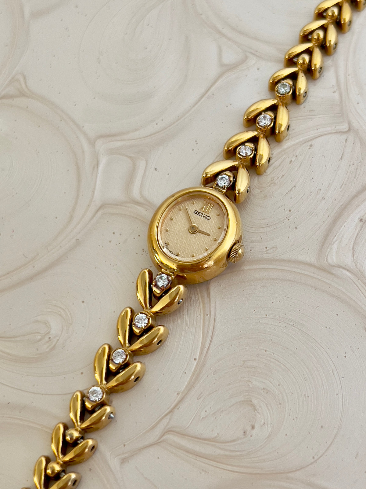 Detail of the gold-tone bracelet with diamond accents.