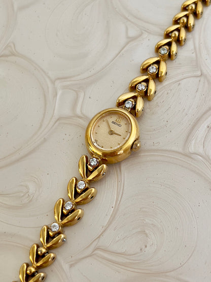Detail of the gold-tone bracelet with diamond accents.