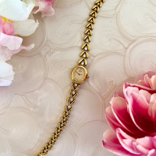 Seiko gold-tone tennis bracelet watch with crystal-set chevron links.