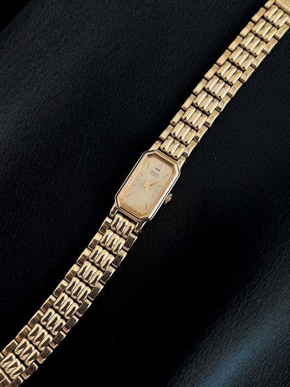 Angled detail of Seiko champagne dial, gold-tone case and bracelet