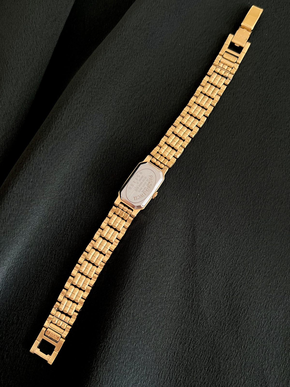 Full reverse view of Seiko caseback, gold-tone bracelet and clasp