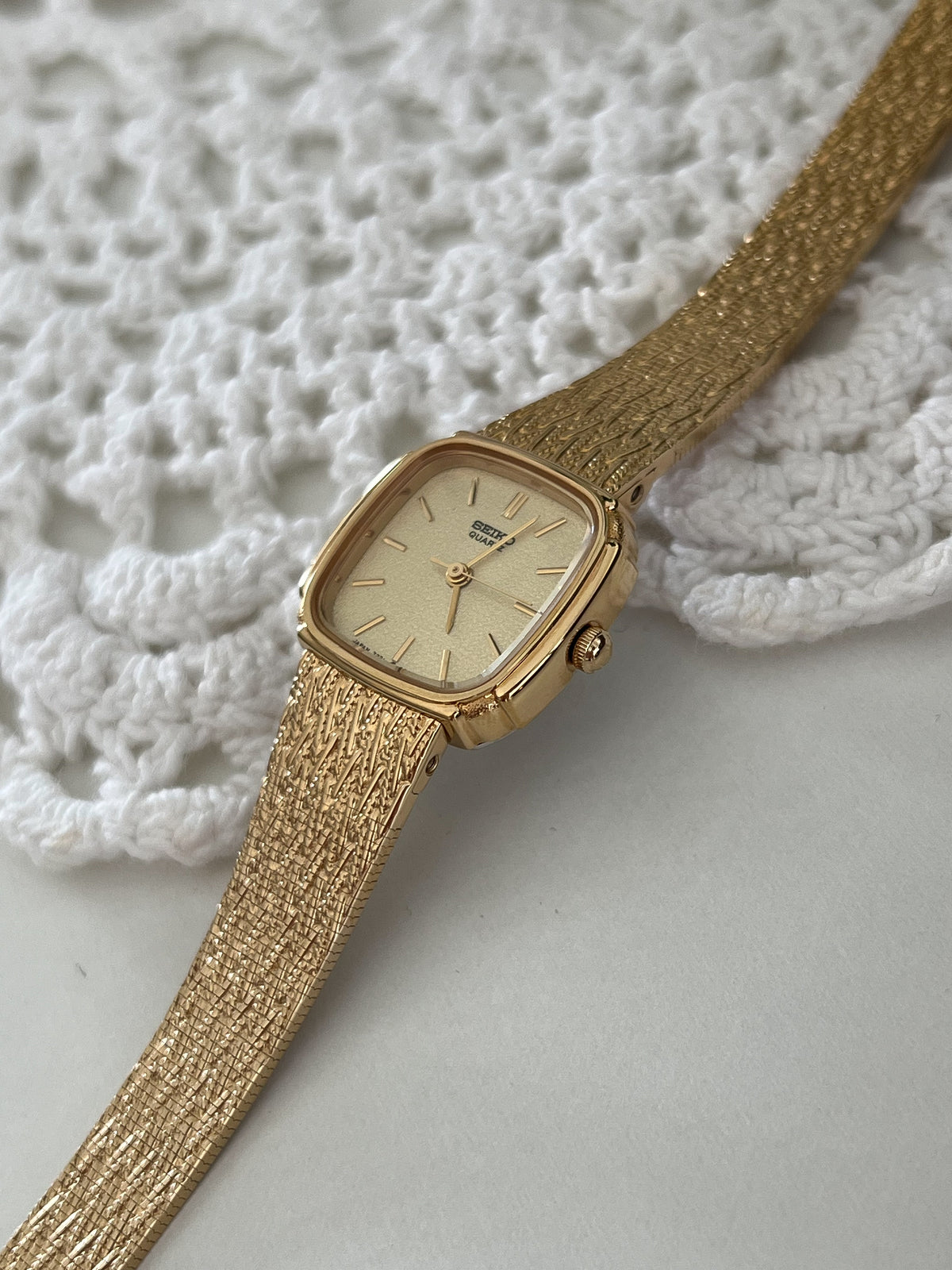 Seiko Gold Cushion Textured Bracelet Women’s Watch — Angled front view on lace
