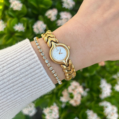 Seiko Golden Leaf women’s watch with a white dial and sculpted gold bracelet worn on the wrist.