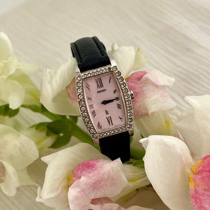 Seiko ladies dress watch with tonneau-shaped silver case, sparkling crystal bezel, white textured dial and black leather strap – vintage Seiko women’s watch available in New Zealand.