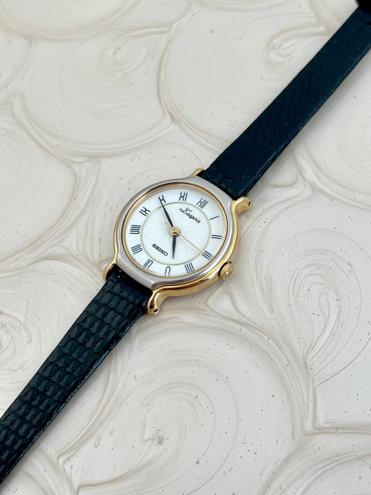 Angled view of the Seiko L'Espoir gold and silver case and sculpted lugs.