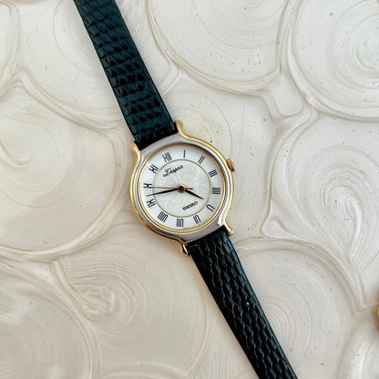 Seiko L'Espoir two-tone watch with black leather strap on a white graphic background.