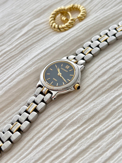 Angled view of the Seiko Lucent 1F21-0G90 navy dial, gold-tone crown and two-tone bracelet