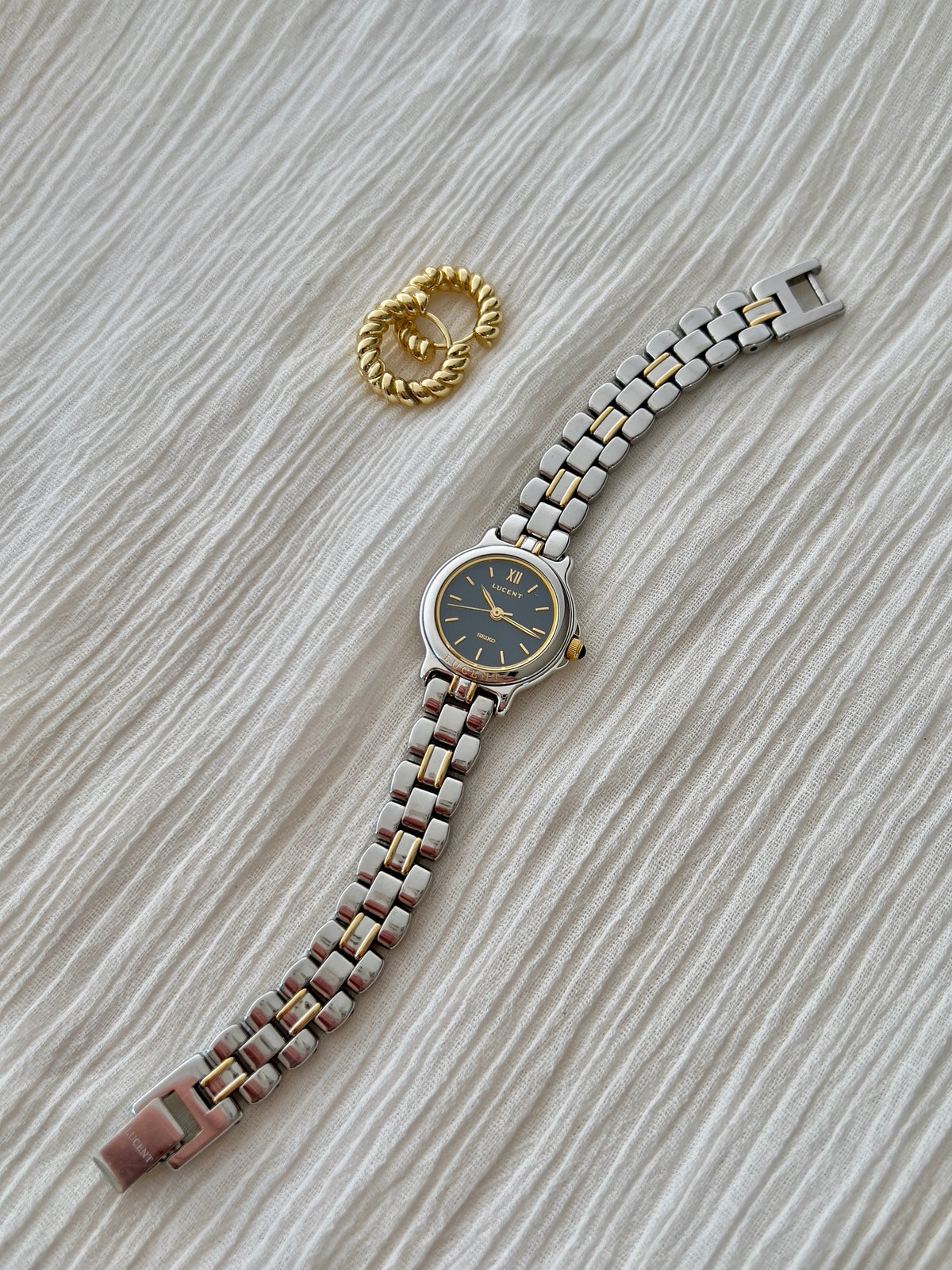 Seiko Lucent 1F21-0G90 laid flat, showing the navy dial and full two-tone bracelet