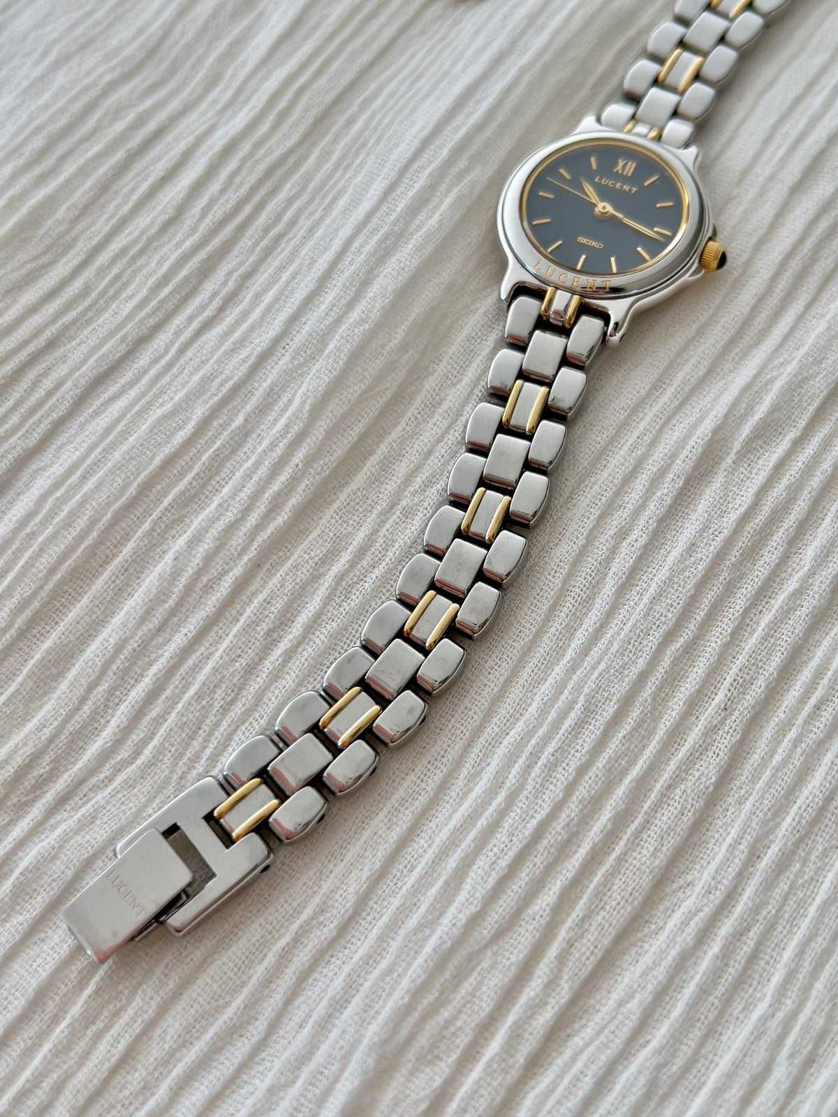 Close view of the Seiko Lucent 1F21-0G90 silver-and-gold bracelet and folding clasp