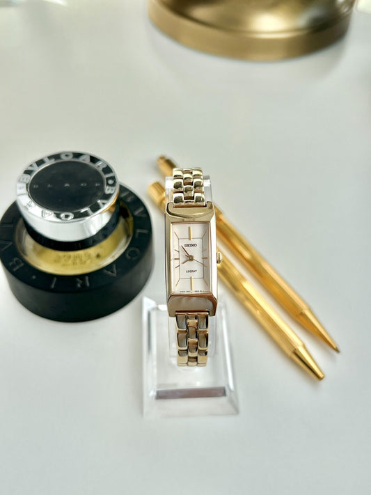 Front view of a Seiko Lucent women’s watch with a slender rectangular champagne dial and polished gold tone bracelet.
