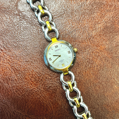 Seiko Lucent Paris two-tone women's watch with mother-of-pearl dial and integrated chain-link bracelet.