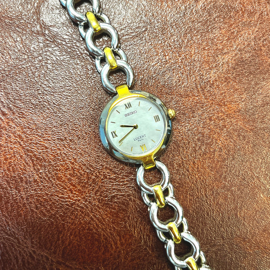 Seiko Lucent Paris two-tone women's watch with mother-of-pearl dial and integrated chain-link bracelet.