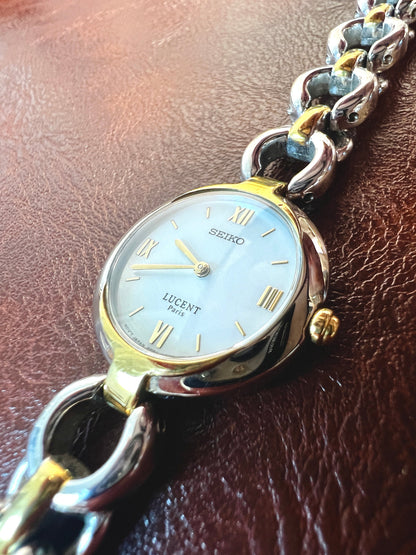 Vintage Seiko Lucent Paris women's watch with silver and gold-tone chain bracelet and Roman numeral markers.