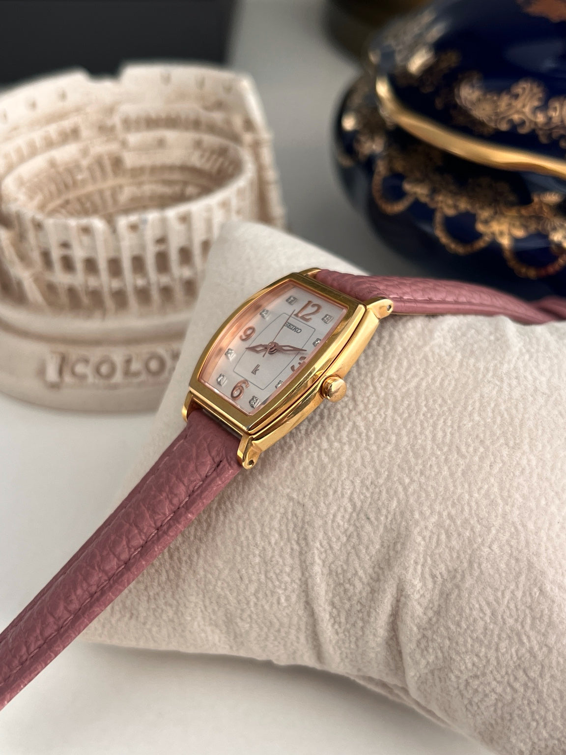 Side profile of the Seiko Lukia showing its gold tone case, curved crystal and pink leather strap