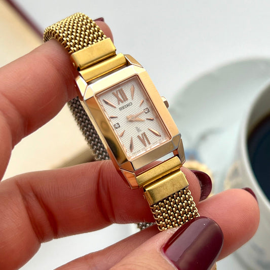 Seiko Lukia gold tank watch with Italian elastic mesh bracelet shown on a wrist.