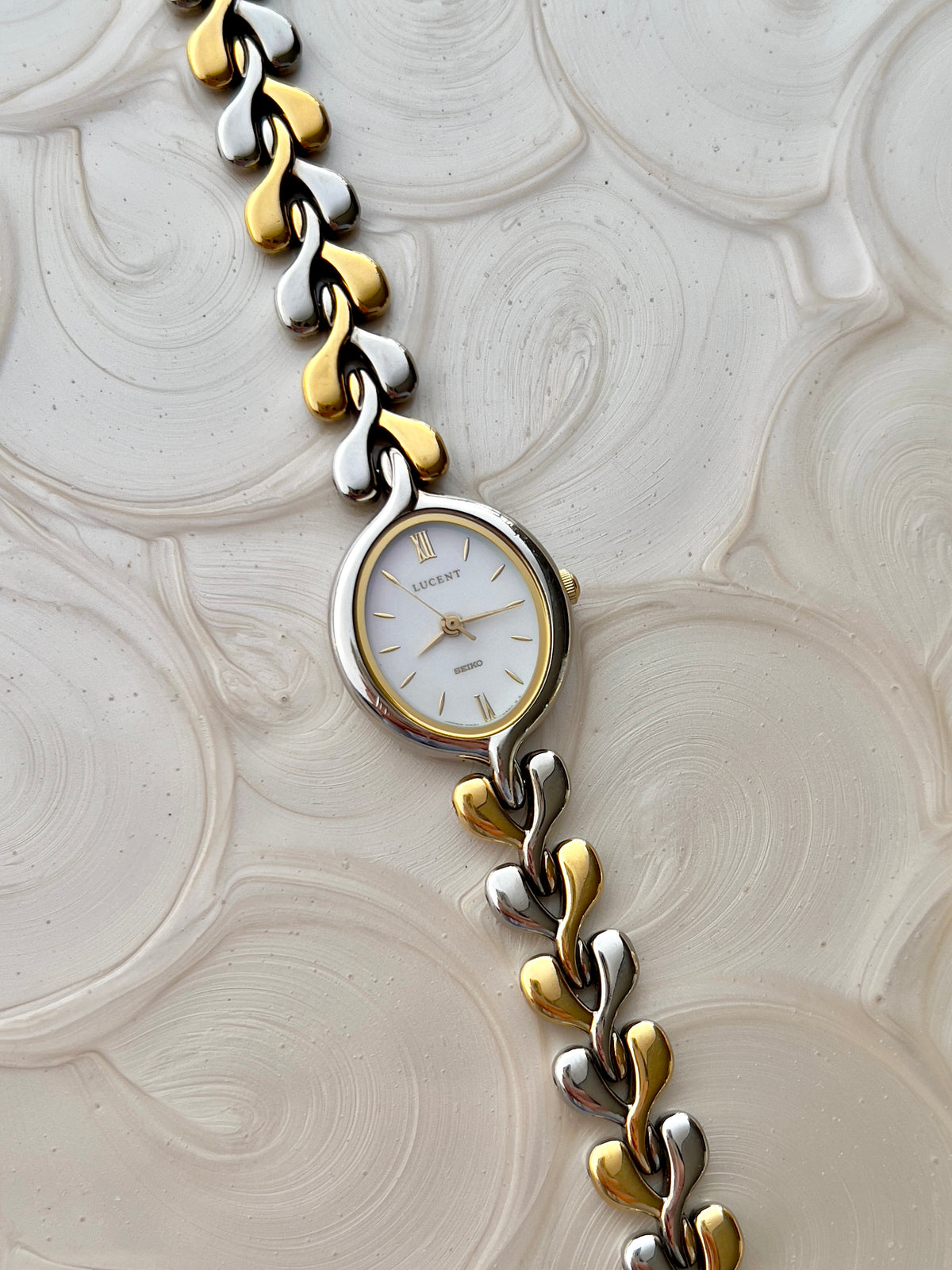 Seiko Lucent pearlescent dial and interlocking two-tone bracelet laid flat