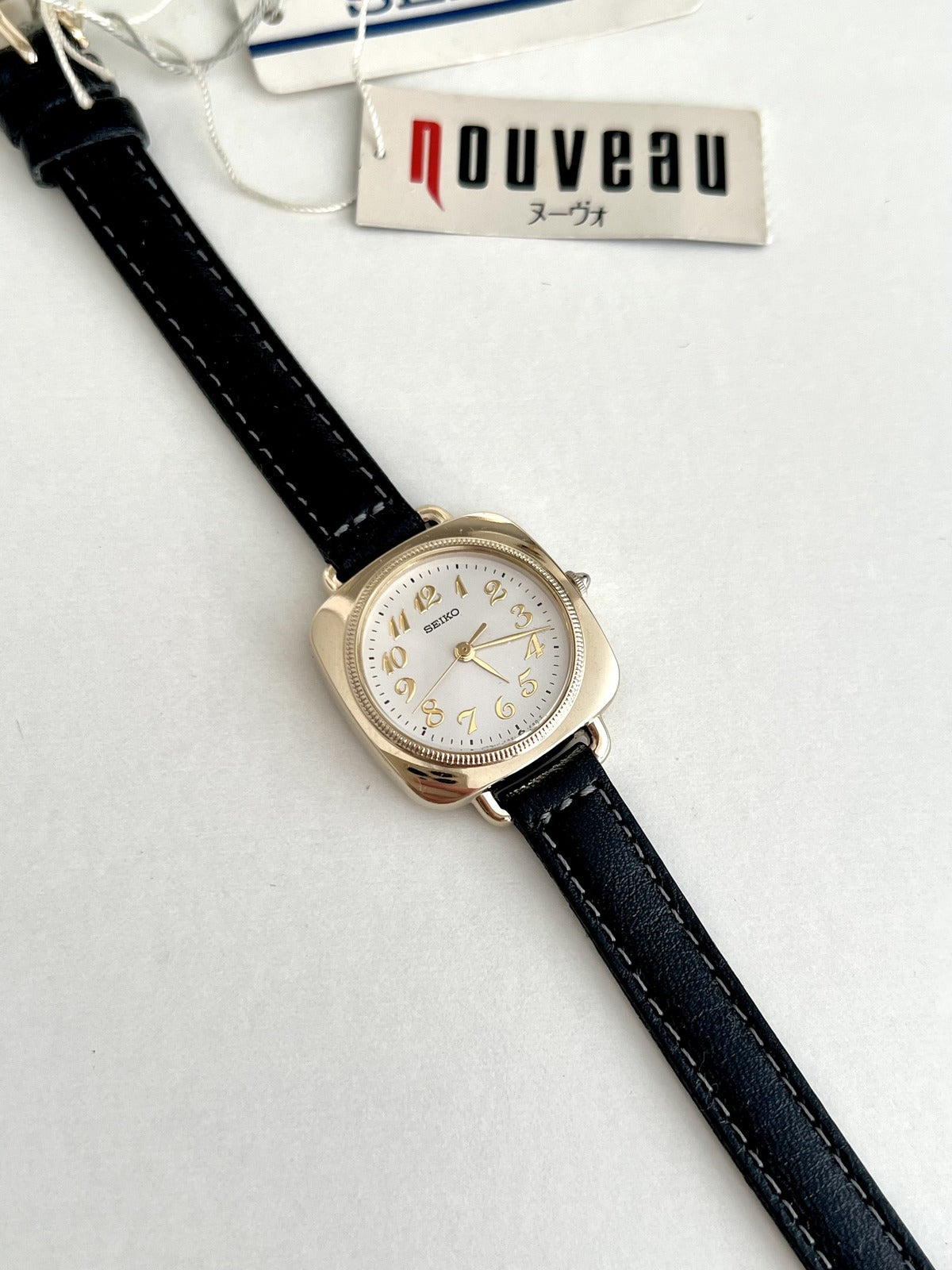 Seiko Nouveau 7321-0340 white dial with applied gold Arabic numerals and a finely textured circular bezel.