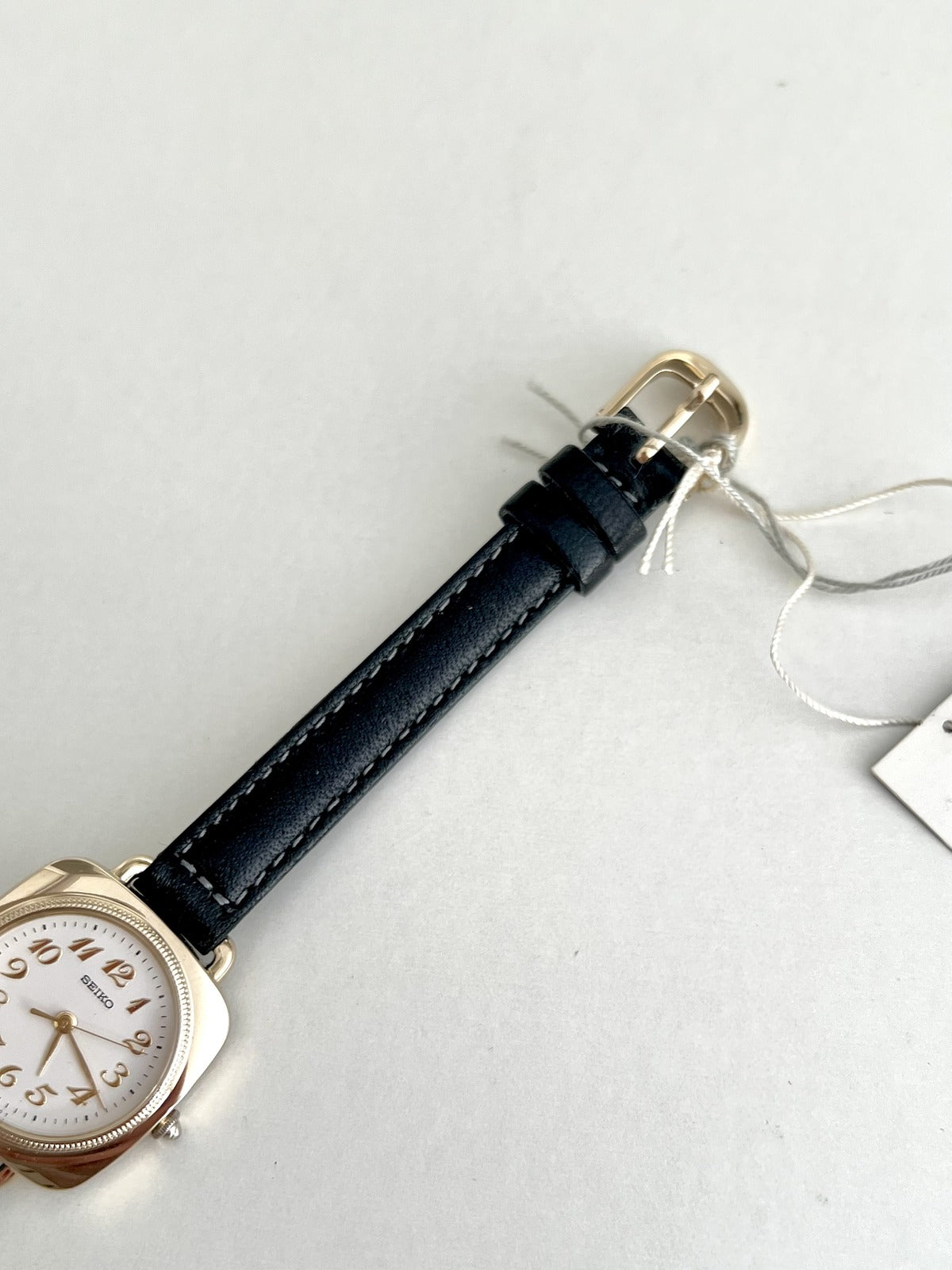 Black stitched leather strap and gold tone pin buckle on the Seiko Nouveau 7321-0340.