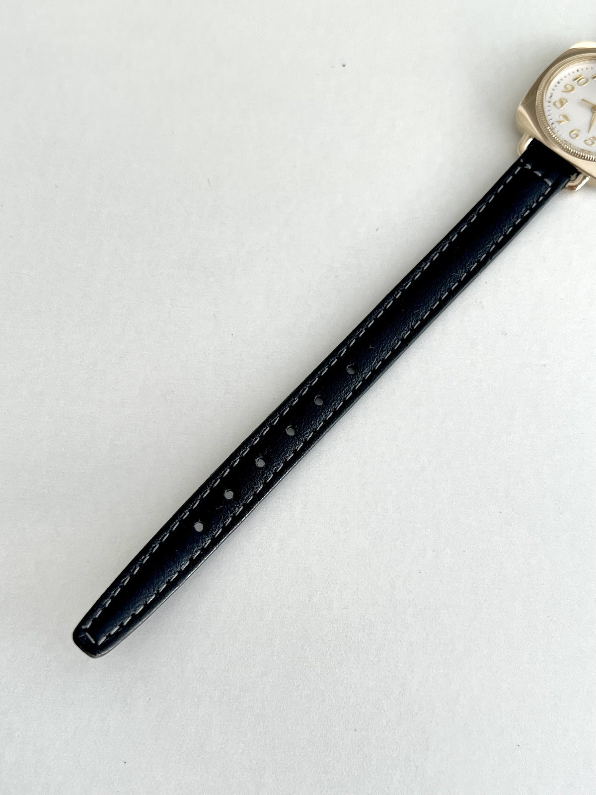 Adjustable black leather strap with contrast stitching and buckle holes on the Seiko Nouveau 7321-0340.