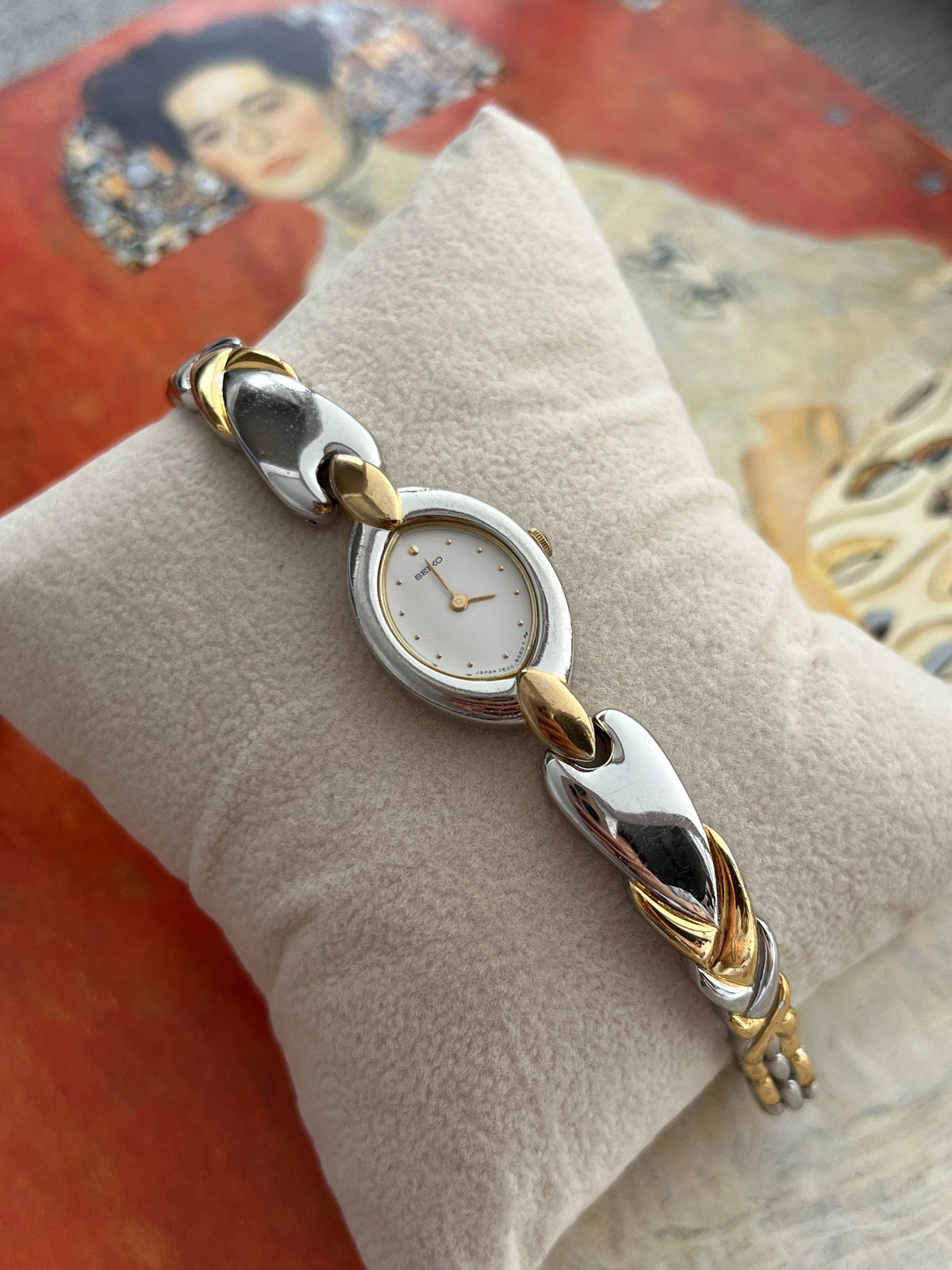 Seiko oval silver tone case and sweeping gold tone connectors on the sculpted bracelet