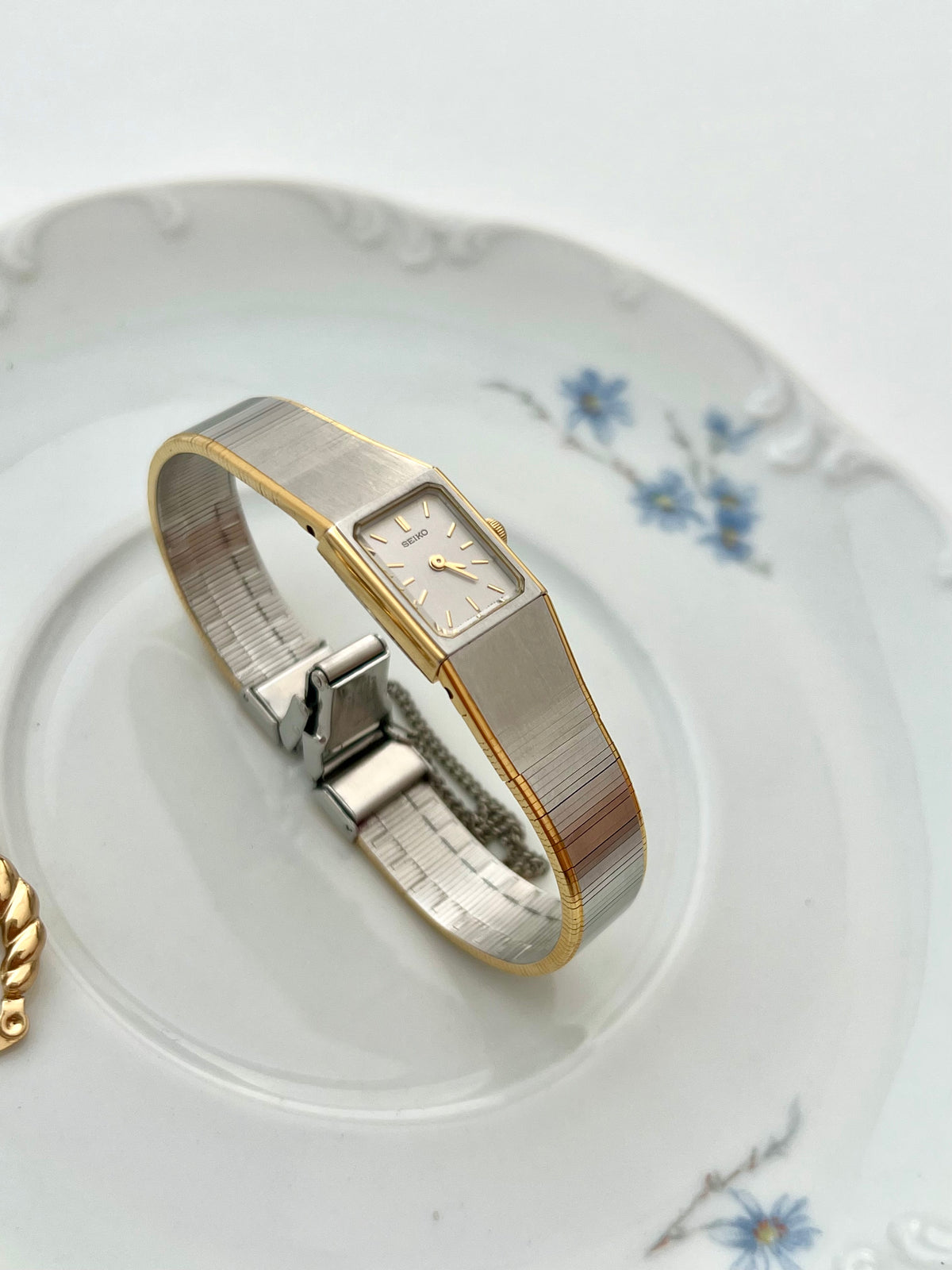 Close-up of the Seiko silver satin dial with slim gold baton markers.