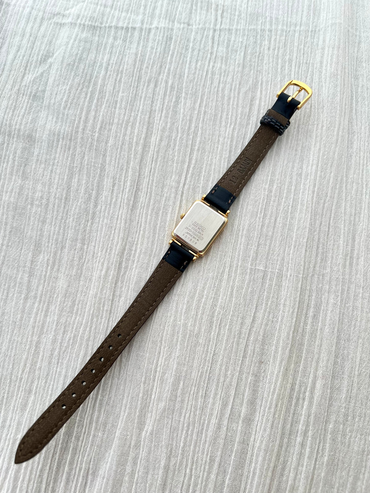 Detail of the aftermarket black leather strap on the Seiko Porte watch.