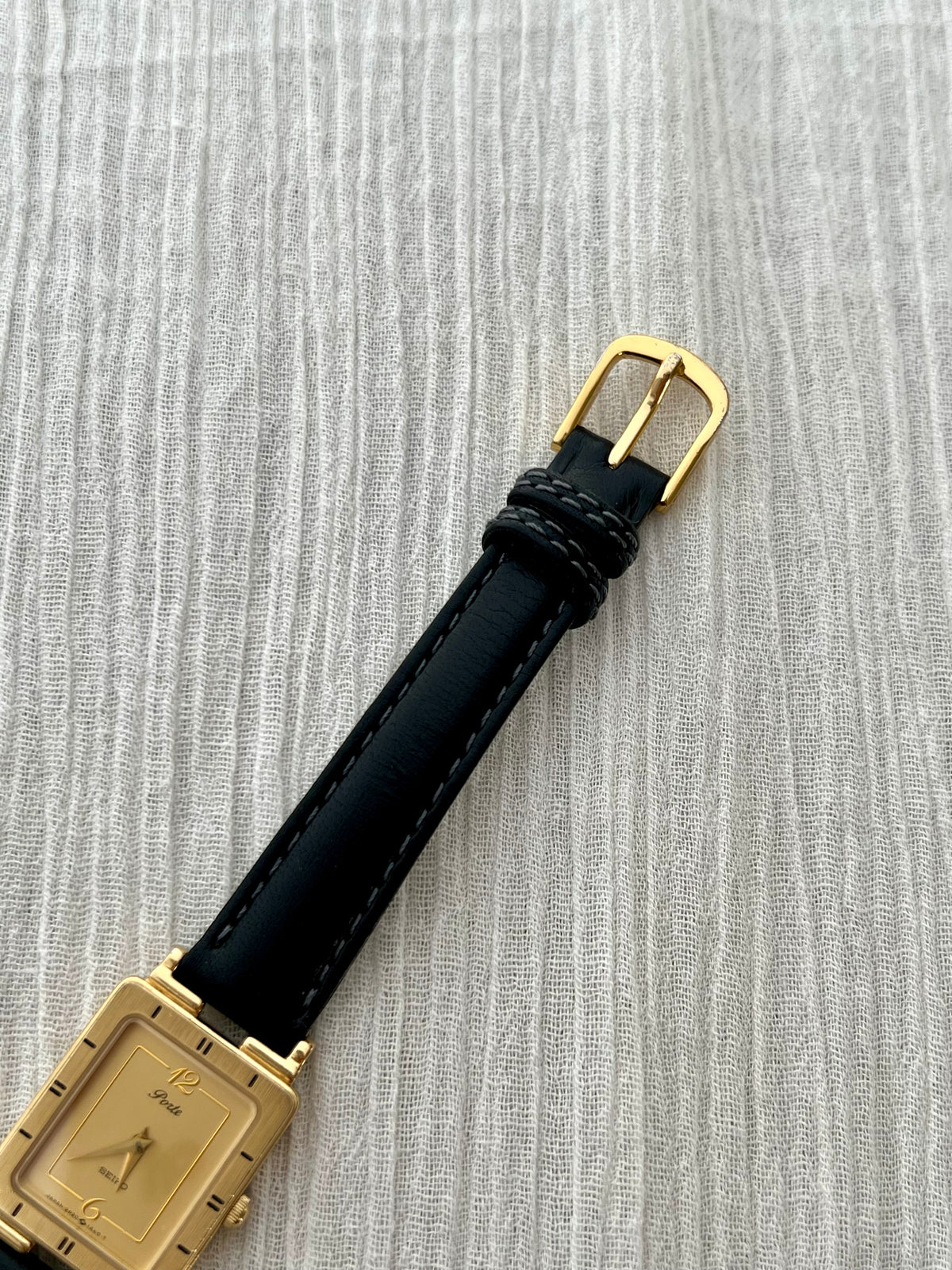 Seiko Porte Art Deco watch shown on a wrist with its black leather strap.
