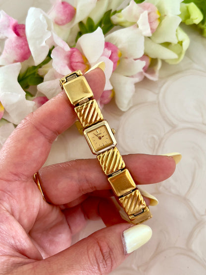 Close-up of the square gold-tone dial on the Seiko watch.