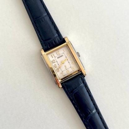 Seiko square gold tone women’s watch with pale champagne dial and black leather strap