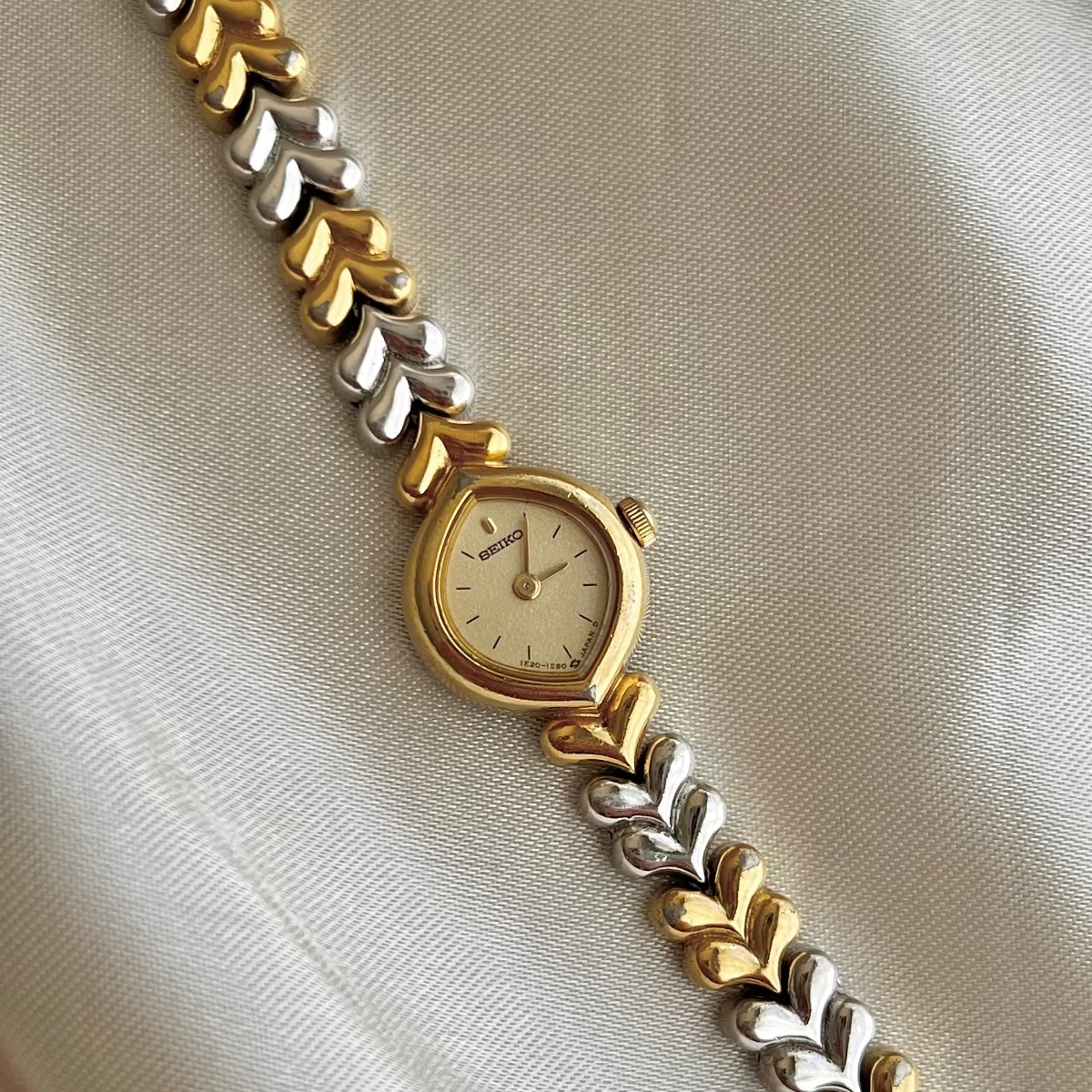 Seiko Champagne Dial Tear Drop Watch with Two-Tone Leaf-Link Bracelet — watch face and case shown from the front.