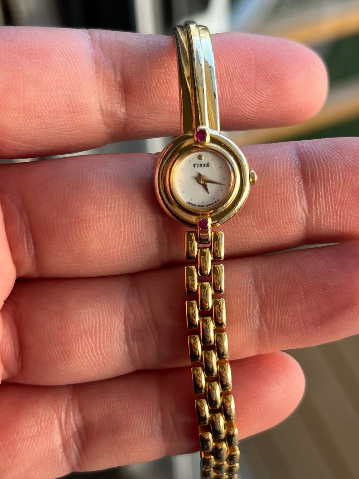 Seiko Tissé 1E20 2030 women’s watch with ivory dial, red stone accents and gold tone bangle bracelet