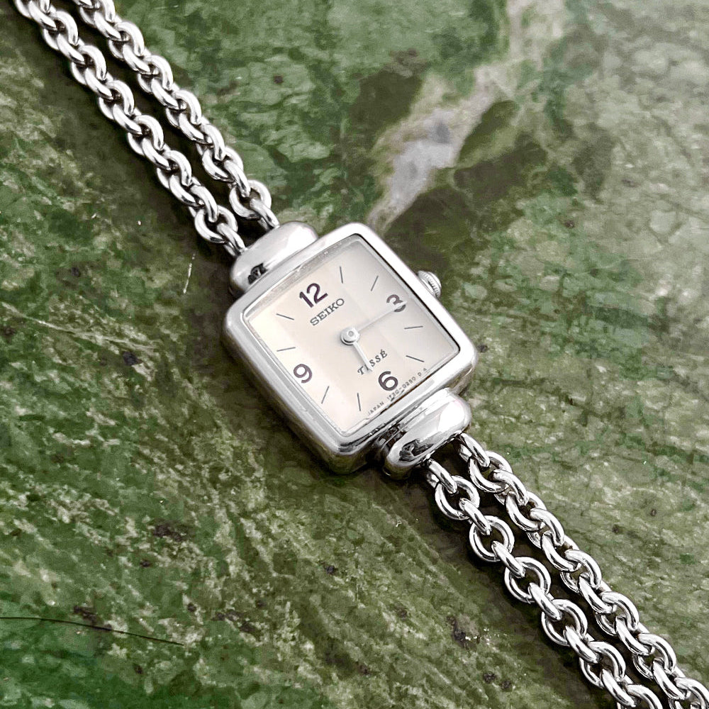 Front view of the Seiko Tissé silver bracelet watch with off-white dial.