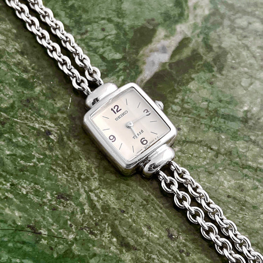 Front view of the Seiko Tissé silver bracelet watch with off-white dial.
