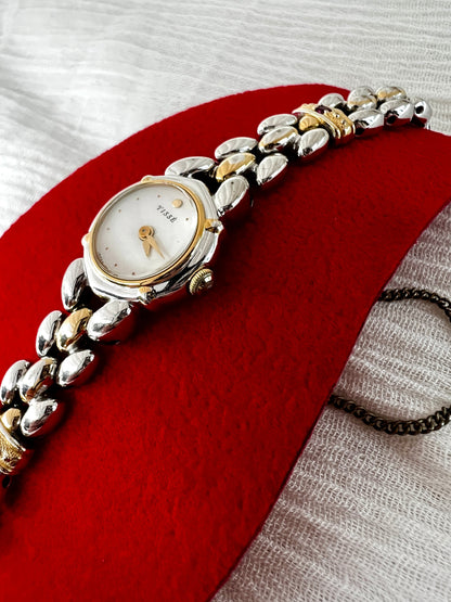 Seiko Tisse Mother of Pearl Women’s Watch with Ruby Bracelet Accents — angled close view of round case.