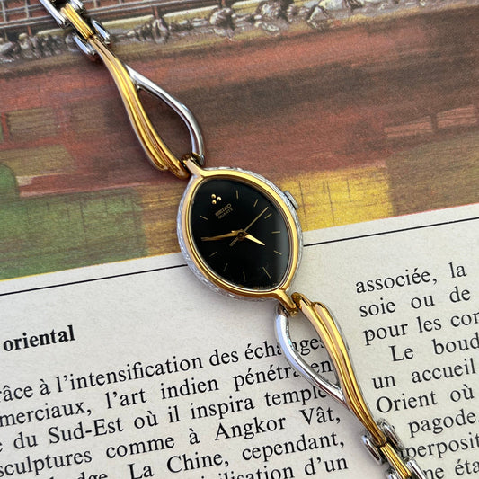 Seiko Tissé oval black dial two-tone watch, dial.