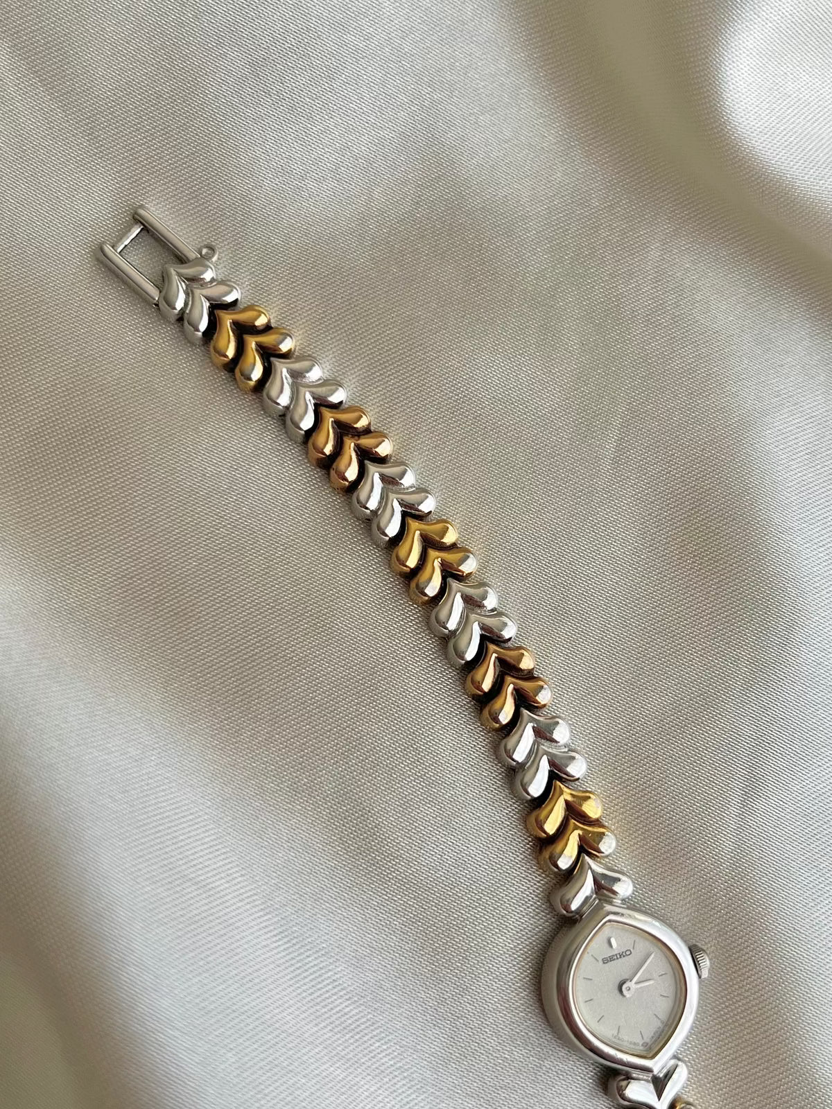 Seiko Silver Teardrop Women’s Watch with Two Tone Leaf Bracelet — angled view of silver dial and leaf links.