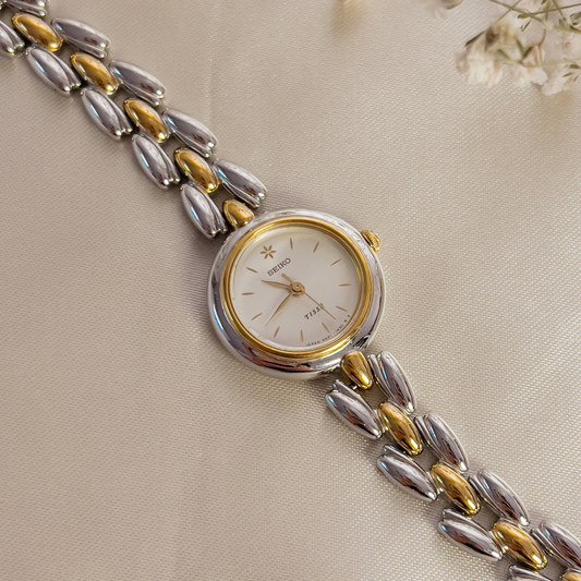 Featured product image: Seiko Tisse two-tone women's watch with white floral dial and gold bezel.