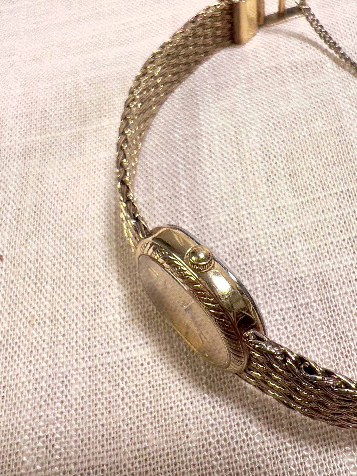 Seiko Gold Toned Oval Watch with a Wreath Textured Case — close detail of the dial and band.