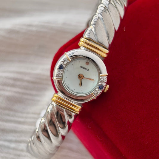 Seiko women’s gold vintage watch displayed softly on a neutral backdrop with its warm pearl dial catching the light