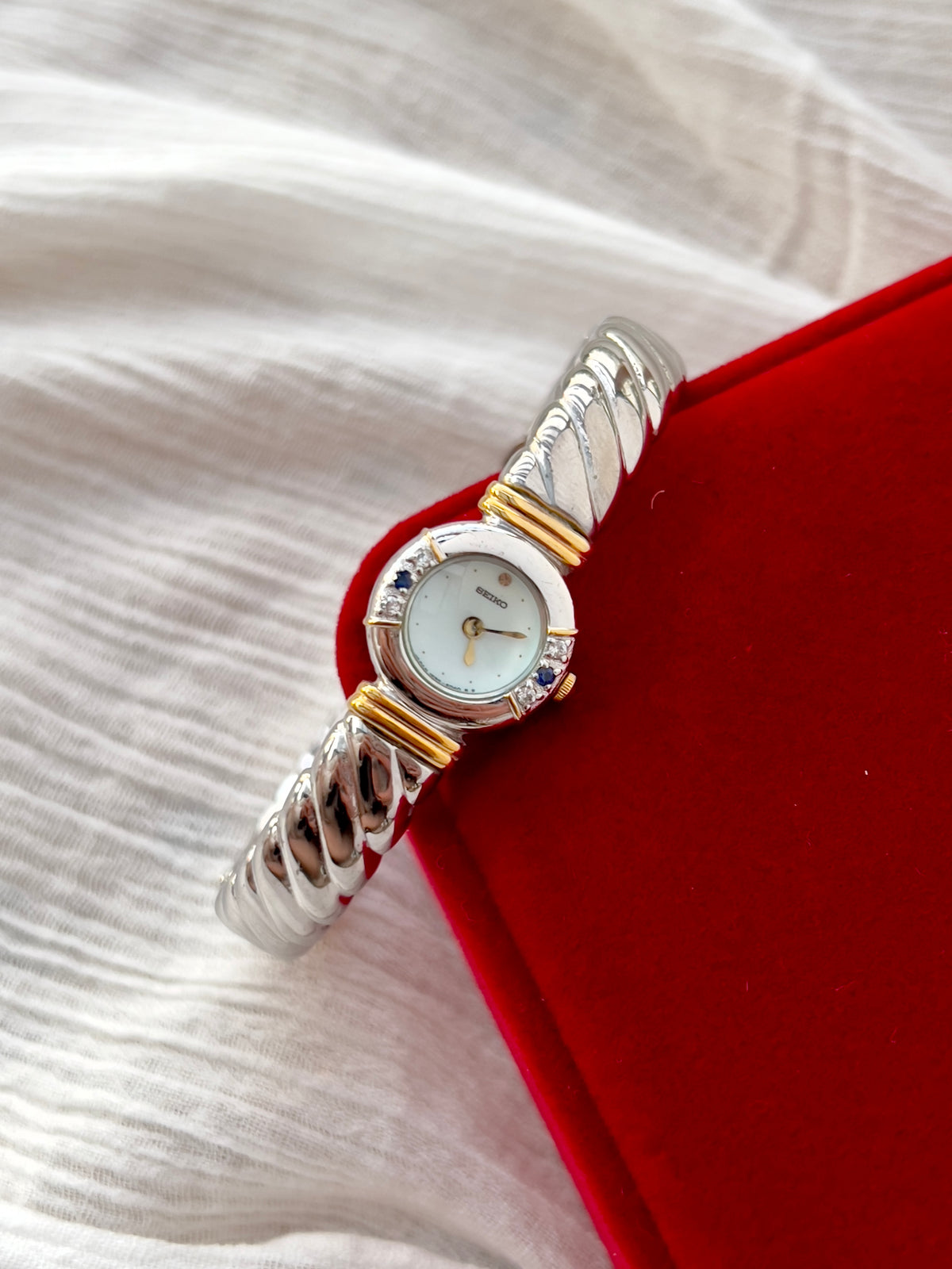 Seiko Bangle Woman's Watch – Two-Tone with Sapphire and Diamond Accents — closer view of the dial and bezel.