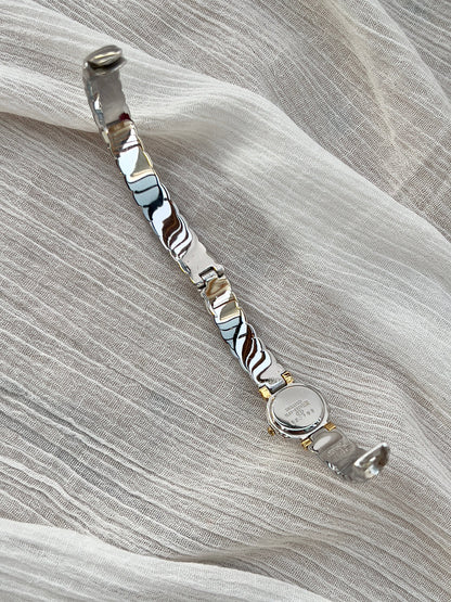 Seiko Bangle Woman's Watch – Two-Tone with Sapphire and Diamond Accents — detail of the case and band.