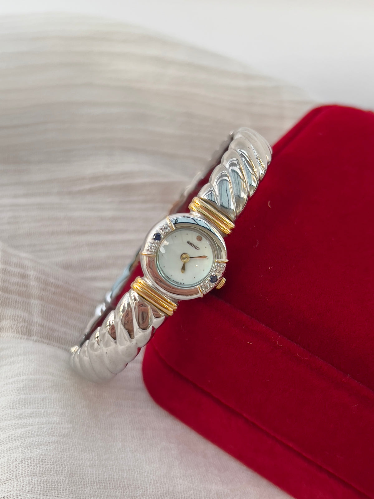 Seiko Bangle Woman's Watch – Two-Tone with Sapphire and Diamond Accents — close view of the watch band and clasp.