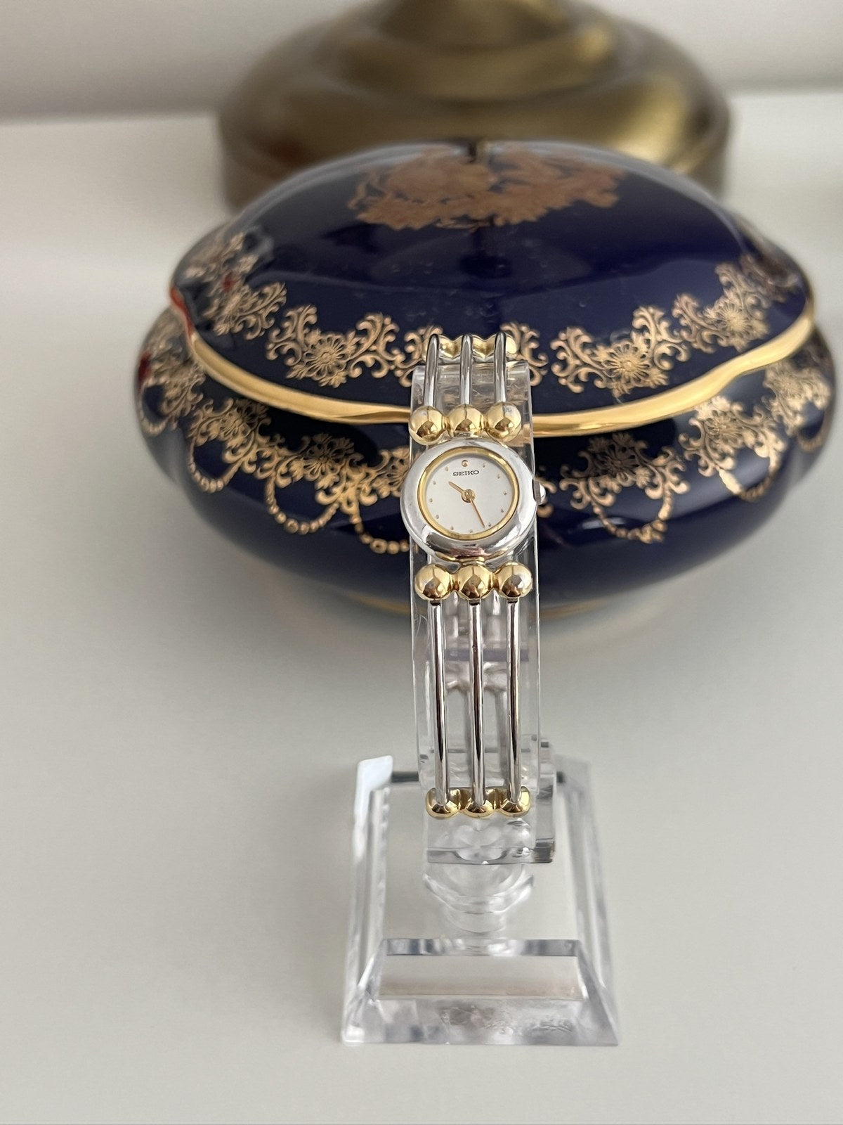 Front view of Seiko silver-and-gold bangle watch showing round white dial and triple-strand bracelet