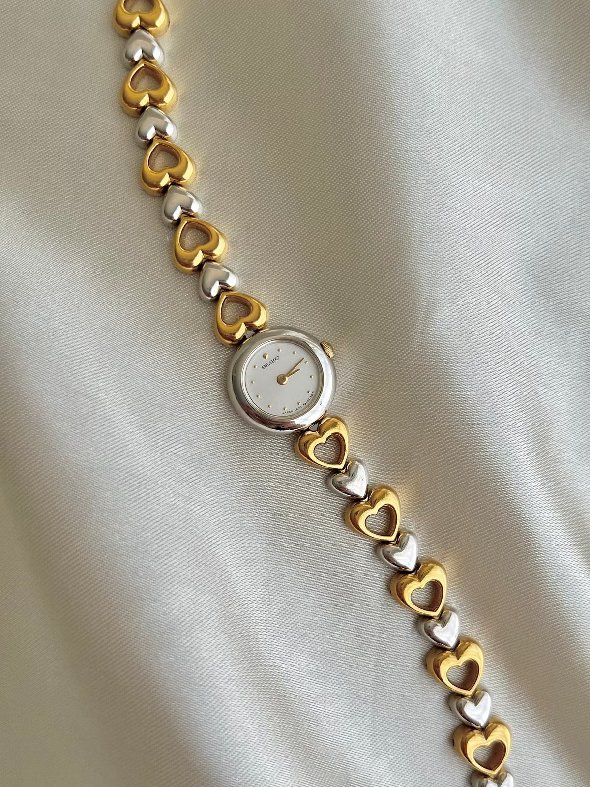 Angled view of the Seiko two-tone hearts bracelet watch.