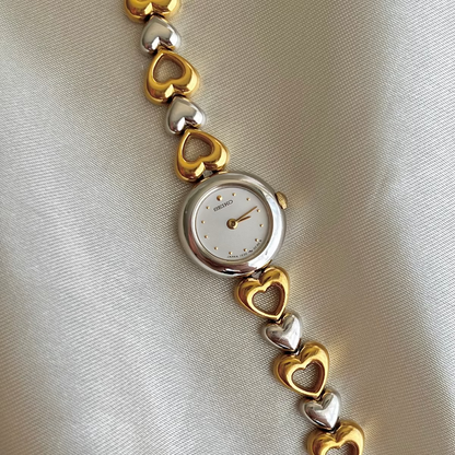 Front view of the Seiko two-tone heart bracelet watch with pearl dial.